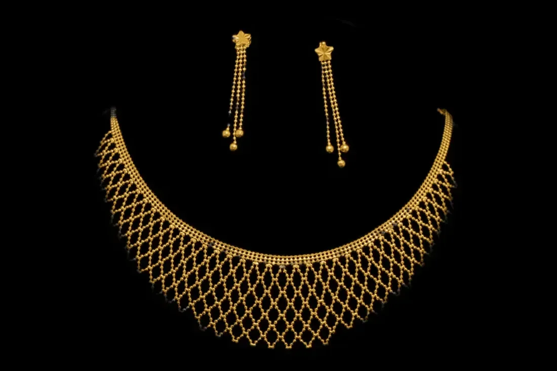 Gold bridal necklace with matching earrings on black velvet
